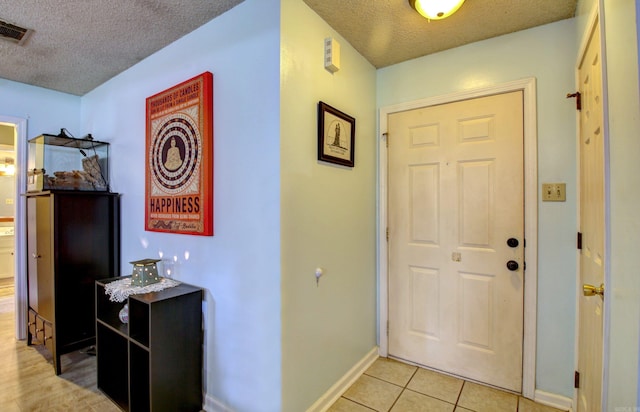 tiled foyer featuring a textured ceiling