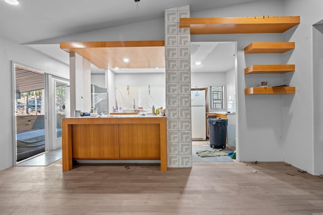 kitchen with white refrigerator, lofted ceiling, and light hardwood / wood-style flooring