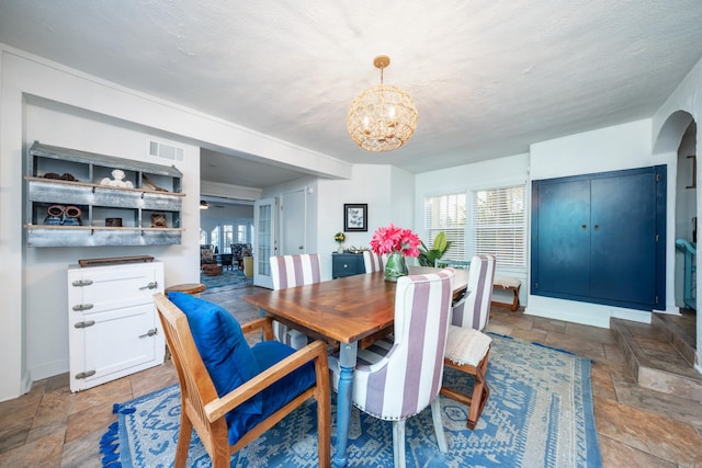 301 Kleinshore # 8, Hot Springs, AR 71913 - dining room with stone tile flooring, a chandelier, healthy amount of natural light, a textured ceiling, and baseboards