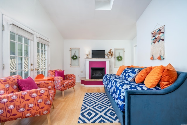 living room featuring wood-type flooring, vaulted ceiling, and french doors