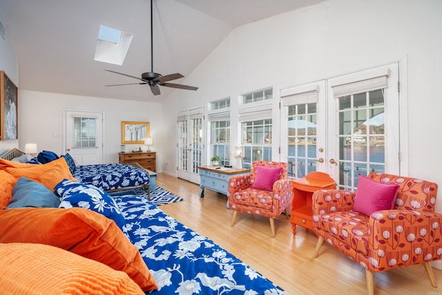 living room featuring ceiling fan, a skylight, hardwood / wood-style floors, and a wealth of natural light