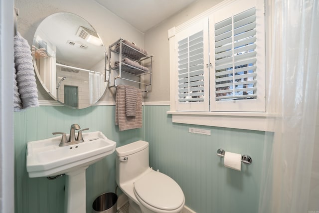 bathroom featuring curtained shower and toilet