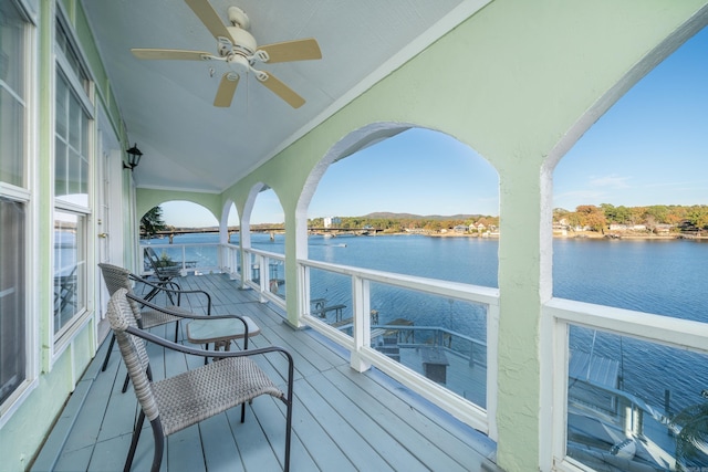 wooden deck featuring a water view and ceiling fan