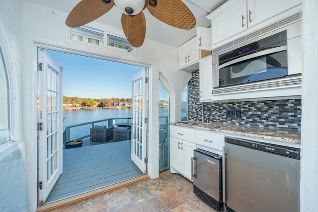 kitchen featuring a water view, ceiling fan, stainless steel appliances, and white cabinets