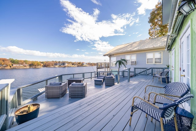 wooden terrace with cooling unit, a water view, and outdoor lounge area