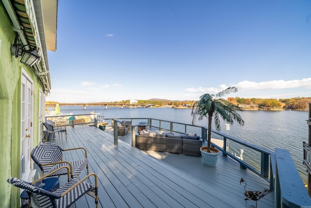 wooden terrace with a water view and an outdoor living space