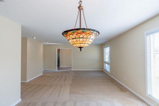 unfurnished room with carpet floors and a textured ceiling