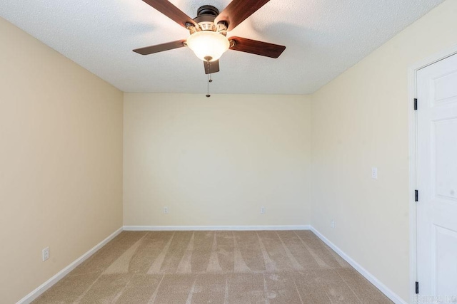 spare room with a textured ceiling, light carpet, and ceiling fan