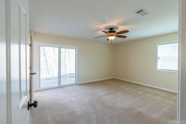 unfurnished room featuring light carpet, ceiling fan, and a healthy amount of sunlight