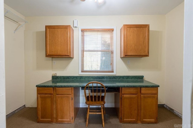 carpeted office space with built in desk