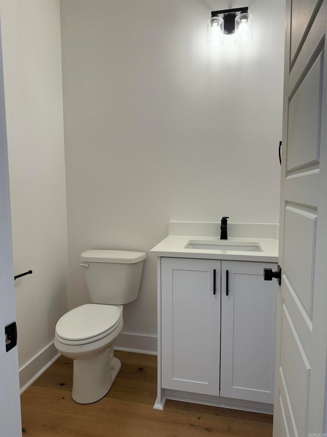 bathroom featuring vanity, toilet, and hardwood / wood-style flooring