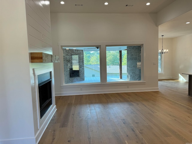 unfurnished living room featuring wood-type flooring and a chandelier