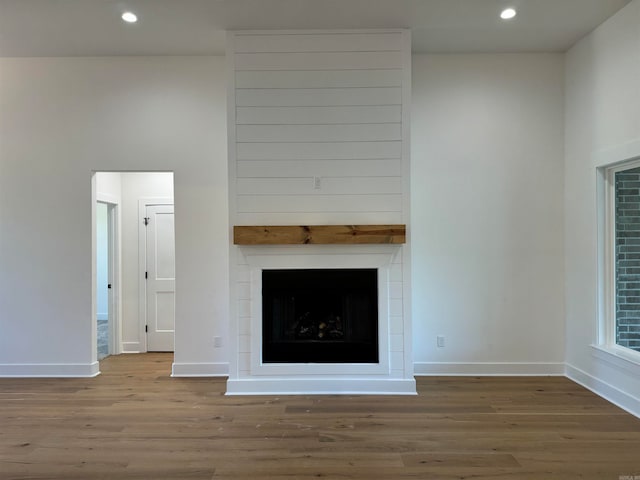 unfurnished living room featuring wood-type flooring and a fireplace