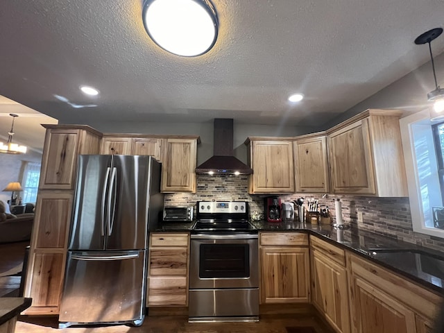 kitchen with dark countertops, a textured ceiling, appliances with stainless steel finishes, and wall chimney range hood