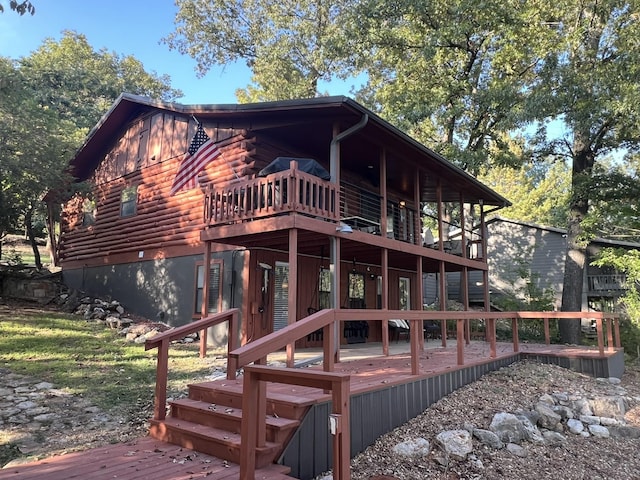 rear view of property featuring a wooden deck and log exterior
