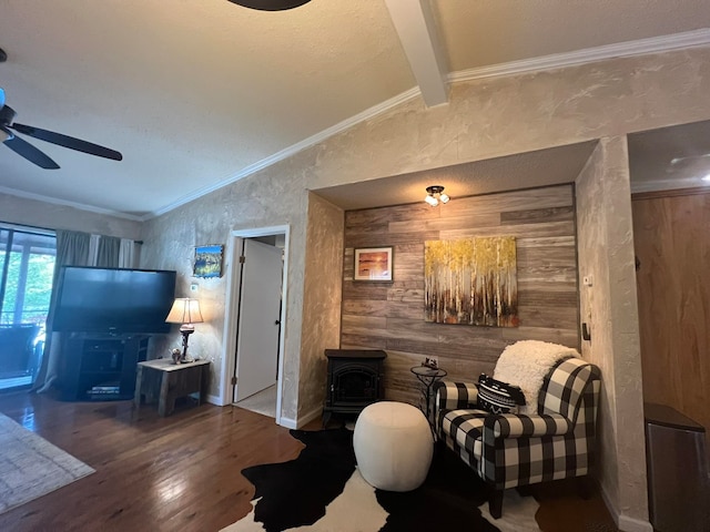 living room featuring ceiling fan, vaulted ceiling with beams, wood walls, wood-type flooring, and crown molding