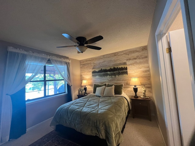 carpeted bedroom with ceiling fan, a textured ceiling, and wood walls