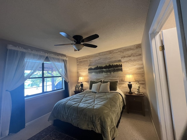 bedroom featuring ceiling fan, an accent wall, wood walls, and a textured ceiling
