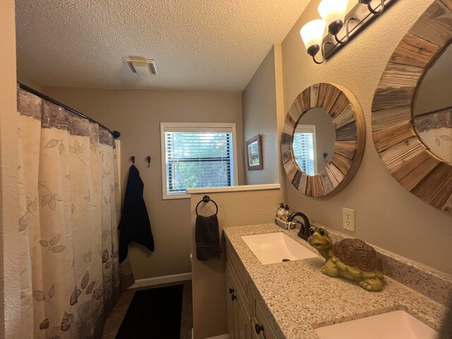 bathroom with a textured ceiling and vanity