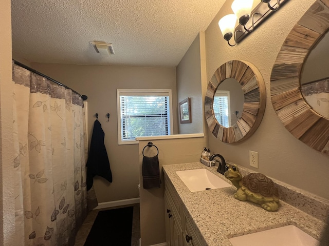 bathroom with visible vents, a textured ceiling, and vanity