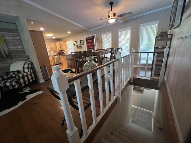 stairway with wood-type flooring, crown molding, and ceiling fan