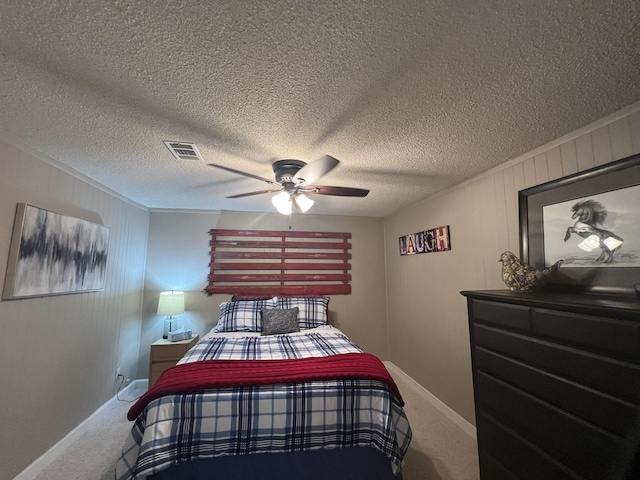 bedroom featuring visible vents, a ceiling fan, baseboards, a textured ceiling, and carpet flooring