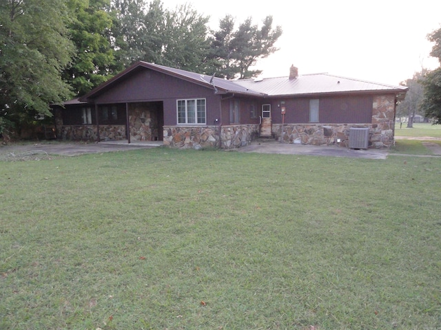 rear view of house with a lawn and central AC unit