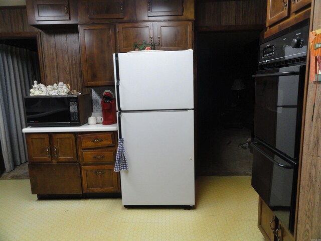 kitchen with dark brown cabinetry and white fridge