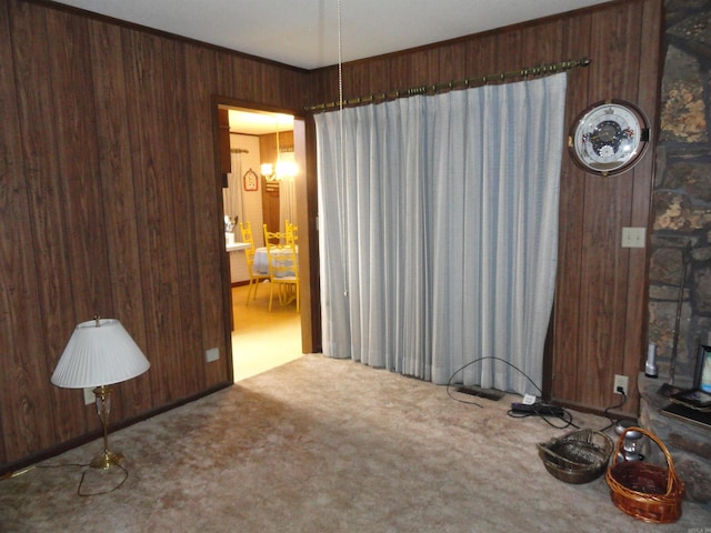 carpeted spare room with wood walls