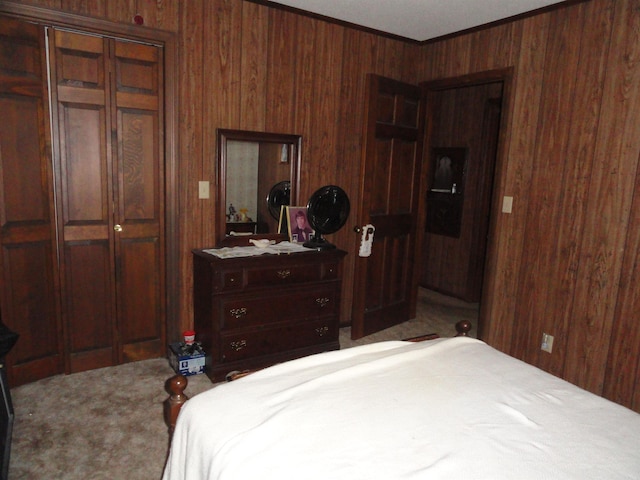 carpeted bedroom featuring wood walls, a closet, and crown molding