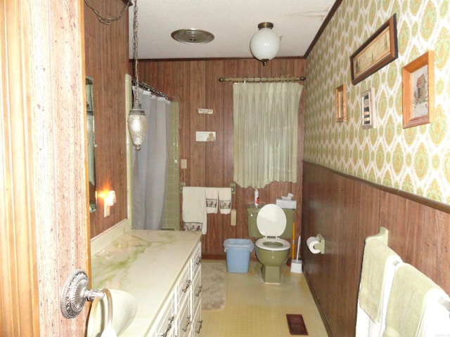 bathroom with vanity, wood walls, crown molding, toilet, and a shower with shower curtain