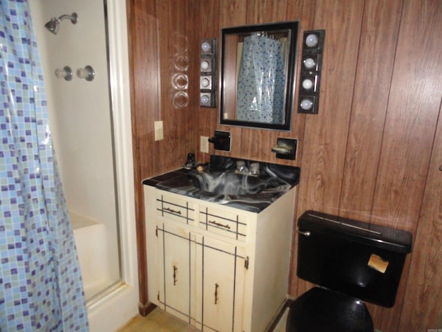 bathroom featuring wooden walls, toilet, vanity, and a shower with shower curtain