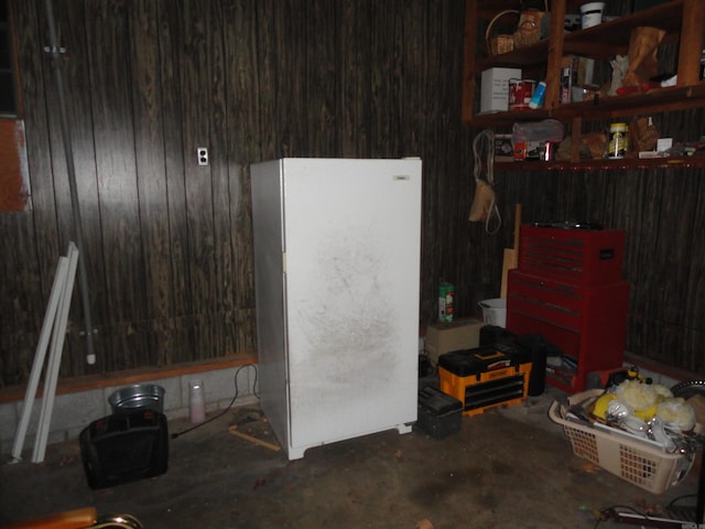 misc room with wooden walls and concrete flooring