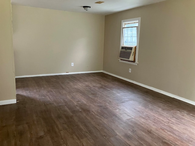 empty room featuring cooling unit and dark hardwood / wood-style flooring