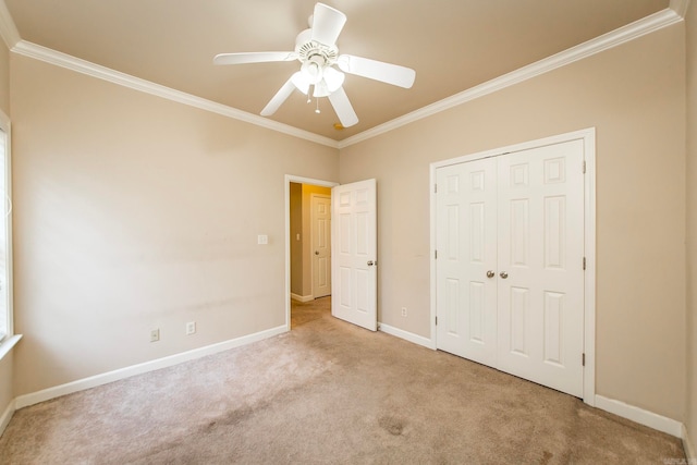 unfurnished bedroom with ceiling fan, a closet, light carpet, and crown molding