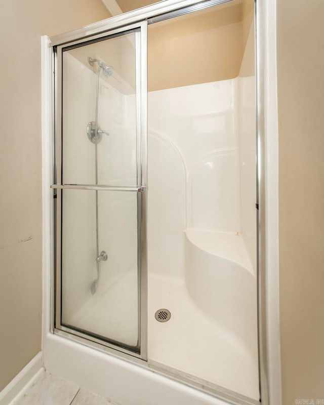 bathroom with tile patterned flooring and a shower with door