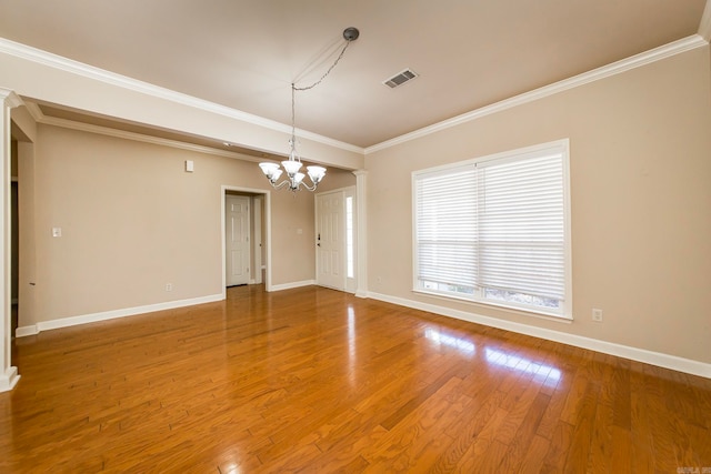 unfurnished room featuring wood-type flooring, a chandelier, and crown molding