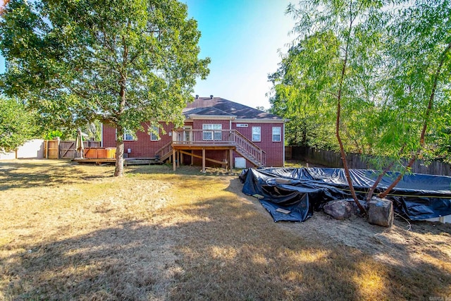 back of house featuring a lawn and a deck