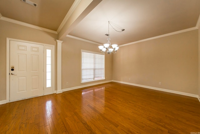 foyer with ornamental molding, an inviting chandelier, and hardwood / wood-style floors