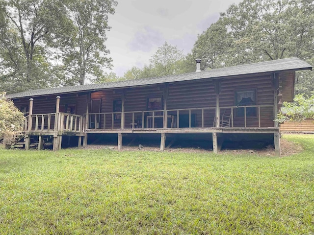 rear view of house with a lawn and a wooden deck