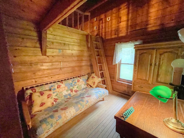 bedroom featuring wood walls and light hardwood / wood-style floors