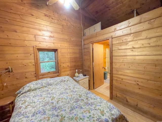 bedroom featuring light hardwood / wood-style flooring, wood walls, and ceiling fan