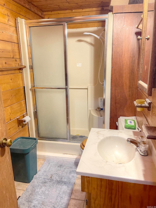 bathroom featuring an enclosed shower, wood walls, tile patterned floors, vanity, and toilet