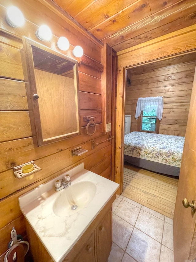 bathroom with vanity, wooden walls, wooden ceiling, and tile patterned floors