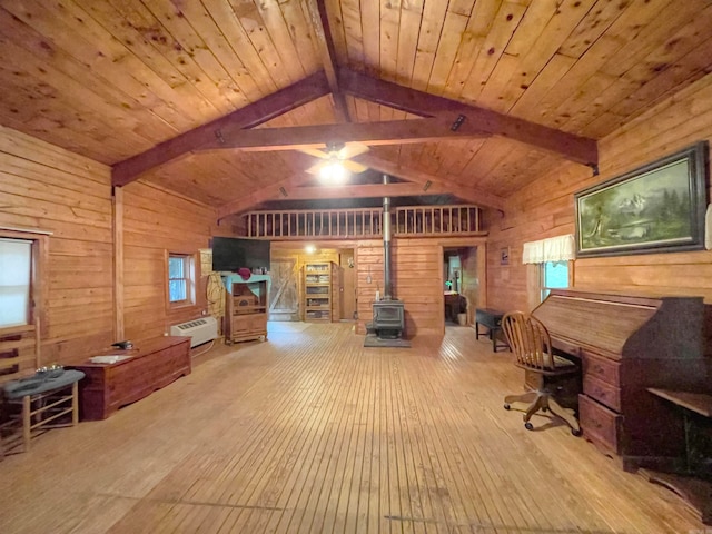 office area featuring lofted ceiling with beams, light wood-type flooring, wood ceiling, a wood stove, and a wall mounted AC