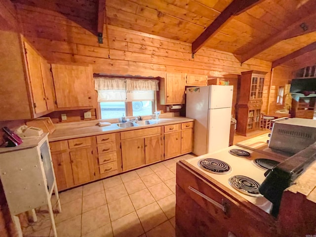 kitchen with light tile patterned flooring, white appliances, wood walls, vaulted ceiling with beams, and sink