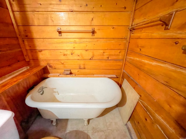 bathroom featuring wooden walls and a tub