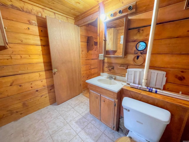 bathroom with vanity, wood ceiling, wood walls, tile patterned floors, and toilet