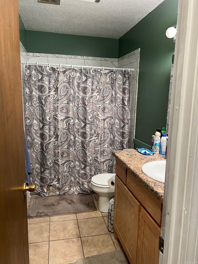 bathroom featuring vanity, toilet, a textured ceiling, and curtained shower