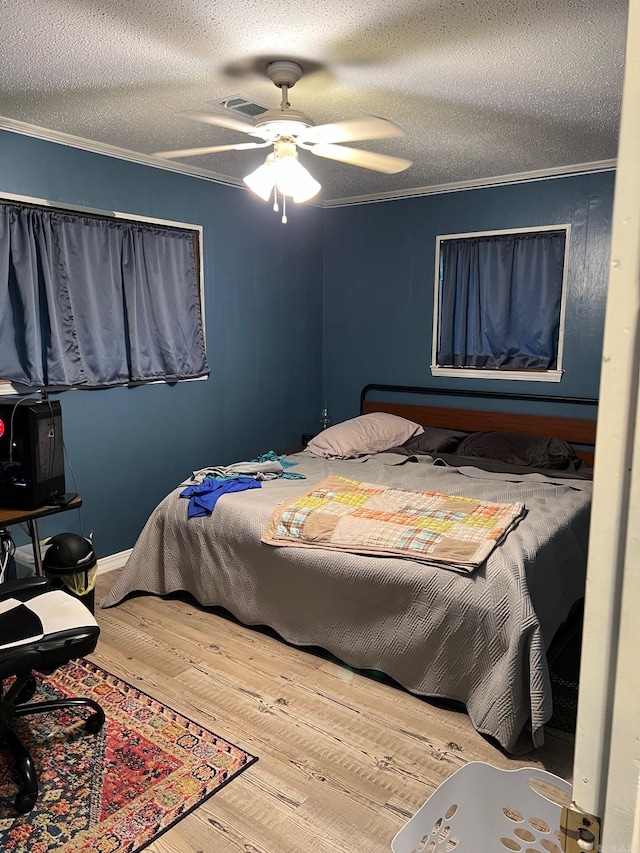 bedroom featuring wood-type flooring, a textured ceiling, crown molding, and ceiling fan